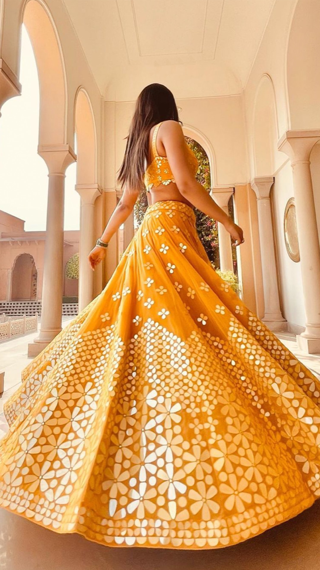 Abhinav Mishra's orange-yellow colored mirror work lehenga painting an idyllic picture of Spring