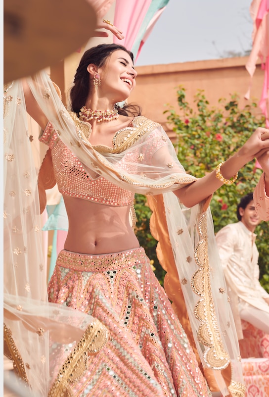 A perfect combination of peach and coral lehenga with iridescent mirror work