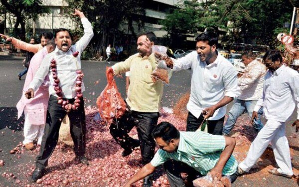सड़क पर तूअर और प्याज़ बिखेरते किसान