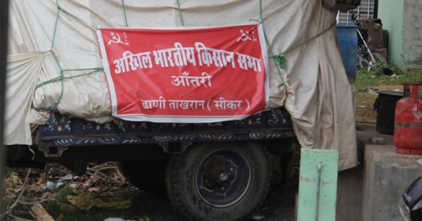 सीकर सब्जी मंडी में टीन शेड के बाहर खड़ा ट्रैक्टर और उस पर लगा पोस्टर