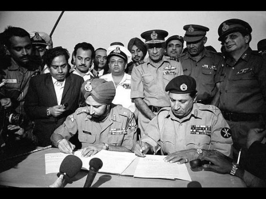 आत्मसमर्पण के दस्तावेजों पर दस्तखत करते हुए जनरल ए.ए.के नियाज़ी