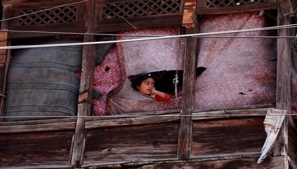 A young girl peeps out from a window during a clash between protesters and Indian police on the occasion of the death anniversary of Burhan Wani, a commander of the Hizbul Mujahideen militant group, in downtown Srinagar July 8, 2017. REUTERS/Danish Ismail