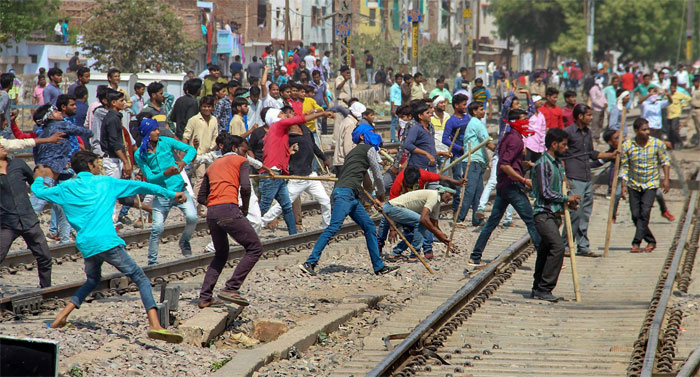 कई जगहों पर पटरियां उखाड़ी गईं. ट्रेनें रोक दी गईं. प्रदर्शनकारियों की तरफ से पत्थरबाजी हुई. बसों में आग लगाई गई.