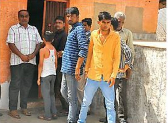 पुजारी की पिटाई के बार मंदिर के पास खड़े गुस्साए लोग.