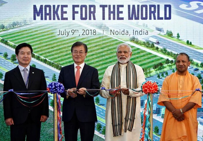 तस्वीर में बाईं तरफ से दूसरे नंबर पर हैं मून जे-इन. उनके बगल में हैं प्रधानमंत्री नरेंद्र मोदी. सबसे दाहिनी तरफ हैं उत्तर प्रदेश के मुख्यमंत्री योगी आदित्यनाथ. ये मौका है नोएडा में सैमसंग इलेक्ट्रॉनिक्स स्मार्टफोन मैन्युफैक्चरिंग फसिलिटी के उद्घाटन का. समझ लीजिए कि ये दुनिया का सबसे बड़ा स्मार्टफोन कारखाना है (फोटो: रॉयटर्स)