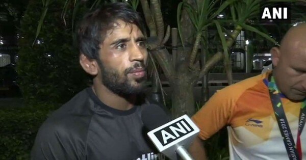 जकार्ता में मेडल जीतने के बाद मीडिया से बात करने के दौरान बजरंग. साथ में हैं उनके कोच.