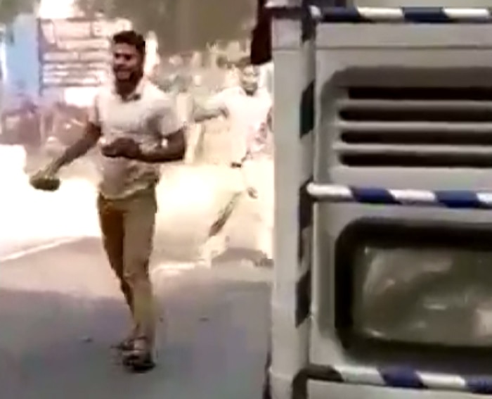 इस फ्रेम को देखिए. सुमित बताए जा रहे इस लड़के की हाथ में पत्थर है.