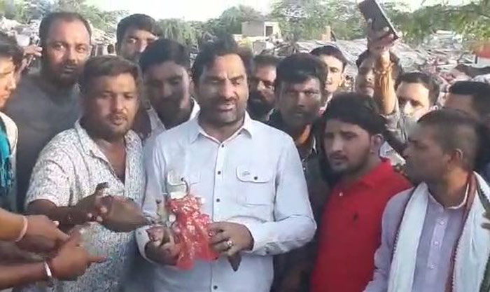 हाथ में मूर्ति पकड़े खड़े सांसद हनुमान बेनीवाल.