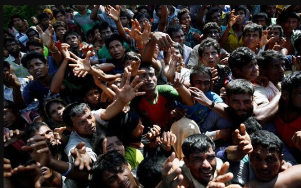 रोहिंग्या मुस्लिम शरणार्थी एक कैम्प के खाने के पैकेट लेने का इंतेज़ार करते. (फ़ाइल फ़ोटो) रोहिंग्या मुस्लिमों को म्यांमार के रिखाइन प्रांत से भागना पड़ा था. उन्हें बौद्ध धर्म को तरजीह देने वाली सरकार और आर्मी द्वारा की प्रताड़ना की वजह से म्यांमार छोड़ना पड़ा है.