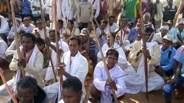 आदिवासी तीर कमानों के साथ गांव में बाहरी लोगों को घुसने से रोक रहे हैं. आदिवासी तीर कमानों के साथ गांव में बाहरी लोगों को घुसने से रोक रहे हैं.