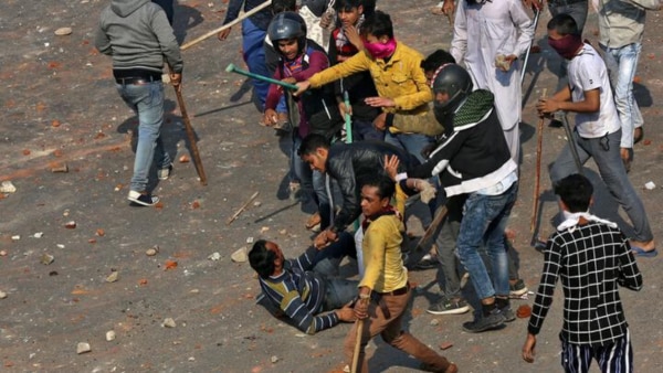 इस तस्वीर में एक गुट के कई सारे लोग एक आदमी को बुरी तरह लाठियों से पीटते हुए दिख रहे हैं. क्रेडिट- रॉयटर्स. Caa Protest 5