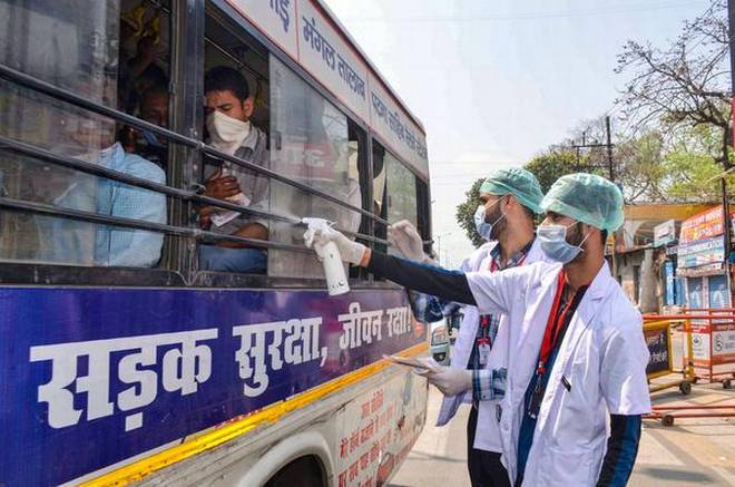 पटना में बस यात्रियों को सैनिटाइज़र देते स्वास्थ्यकर्मी (तस्वीर : PTI) Patna Pti