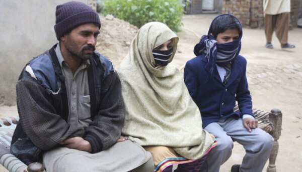 ये स्कूली ड्रेस में बैठा बच्चा मुहिम्मन है. साथ में उसके माता-पिता. (फोटो- AP Photo/K.M. Chaudhry) Muhimman 11