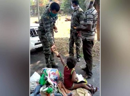 बच्ची को खाने-पीने का सामान देते पुलिस वाले. (तस्वीर: आज तक) At 2