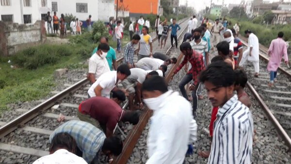 श्रमिक स्पेशल ट्रेन जाने के बाद पटरी को रेलवे ट्रैक से हटाते लोग. (फोटो- जहांगीर आलम) Shramik Special Trains 1