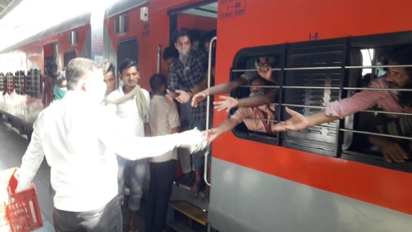 समस्तीपुर स्टेशन में ट्रेन में सवार मज़दूरों को खाना देते रेलवे कर्मचारी. (फोटो- जहांगीर आलम) Shramik Special Trains 4
