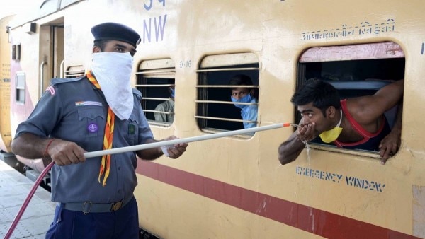 श्रमिक ट्रेन में सवार लोगों को पानी पिलाता एक स्काउट गाइड. (Photo: PTI) श्रमिक ट्रेन में सवार लोगों को पानी पिलाता एक स्काउट गाइड. (Photo: PTI)