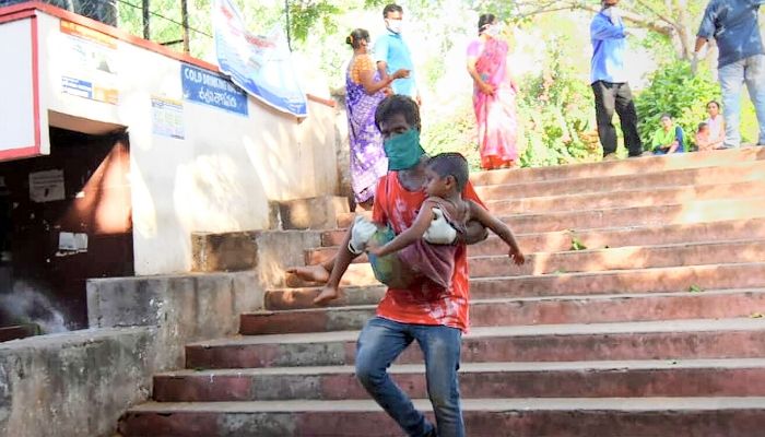 बीमार लोगों में बड़ी संख्या में बच्चे शामिल हैं. अपने बच्चे को अस्पातल में भर्ती कराने के लिए दौड़ता एक पिता. (फोटो-पीटीआई) Vishakhapatnam4