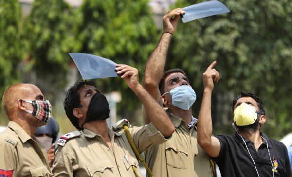 जम्मू में सूर्य ग्रहण को देखने की जुगत लगाते पुलिसकर्मी. (Photo: AP) जम्मू में सूर्य ग्रहण को देखने की जुगत लगाते पुलिसकर्मी. (Photo: AP)
