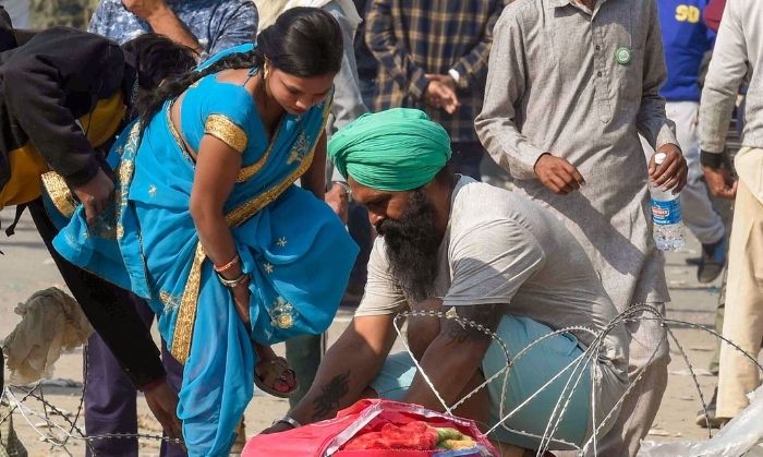 'दिल्ली चलो' मार्च के दौरान सिंघू सीमा पर एक अस्थायी अवरोधक पार करवाने में एक महिला की मदद करता हुआ एक किसान. 29 नवंबर, 2020. (पीटीआई/अतुल यादव) 'दिल्ली चलो' मार्च के दौरान सिंघू सीमा पर एक अस्थायी अवरोधक पार करवाने में एक महिला की मदद करता हुआ एक किसान. 29 नवंबर, 2020. (पीटीआई/अतुल यादव)