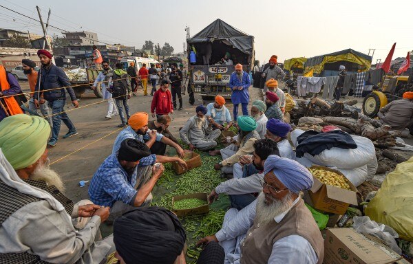 प्रोटेस्ट के दौरान खाने की तैयारी करते किसान. (तस्वीर: PTI) Farmers Agitation At Singhu Border