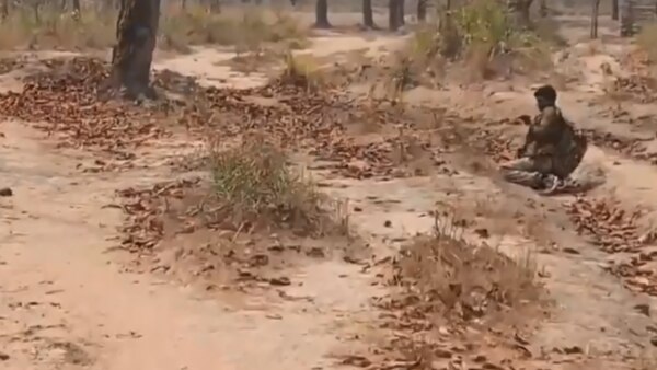 रस्सी के जरिए शव को पलटने की कोशिश करता जवान. फोटो साभार- बस्तर टाकीज Naxal Rassi