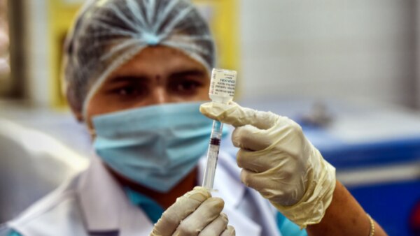 वैक्सीन लगाने की तैयारी करता एक हेल्थ वर्कर. फोटो- PTI Vaccine 2