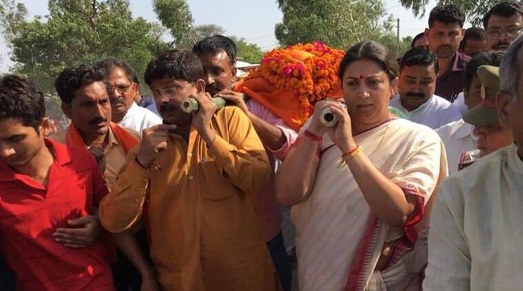 बीजेपी कार्यकर्ता की अर्थी को कंधा देतीं केंद्रीय मंत्री स्मृति ईरानी. (फोटो: PTI) बीजेपी कार्यकर्ता की अर्थी को कंधा देतीं केंद्रीय मंत्री स्मृति ईरानी. (फोटो: PTI)