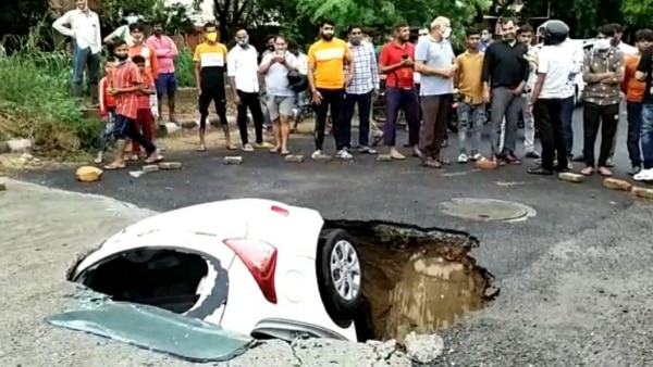 सड़क में समाई कार को देखने के लिए लोगों की भीड़ लग गई. फोटो सोर्स- आजतक Delhi Car 2