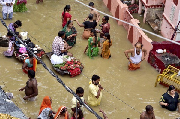 9 अगस्त को गंगा के एक घाट पर पूजा करते कुछ श्रद्धालु. (तस्वीर- पीटीआई) Ganga River Water Level Rises In Varanasi