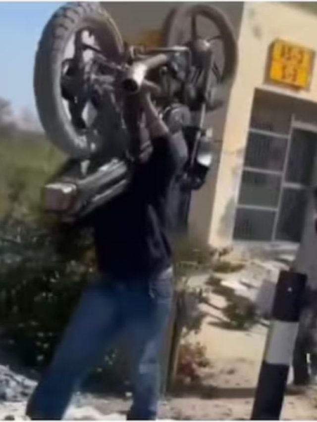 शख्स ने कंधे पर उठाई बाइक, रेलवे ट्रैक पार करता देख दंग रह गए लोग!